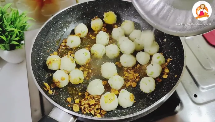 Add the boiled potato balls to the pan. Stir to coat them well with the spice mixture.