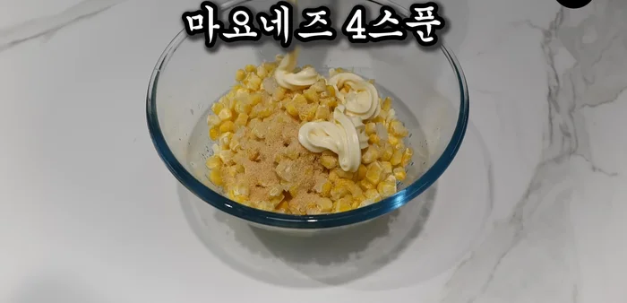 In a bowl, mix together Mozart cheese, sweet corn, sugar, and mayonnaise.