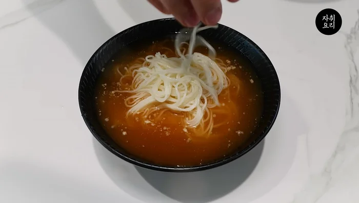 Add the pre-boiled noodles and a sufficient amount of pickled radish kimchi to the broth.