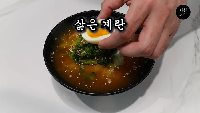 Drizzle with sesame oil, sprinkle with piguwang sesame seeds, and top with a boiled seaweed egg.