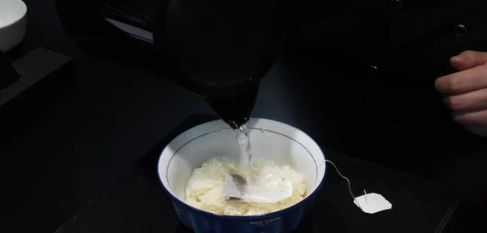 Put the green tea bag in the rice and pour hot water over it.