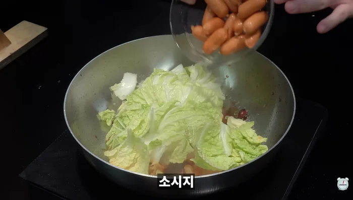 (Optional) Add boiled Lao Ma Ajo Jang, cabbage, sausage, and garlic chives; stir-fry.