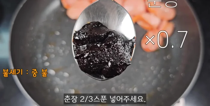 Push sausages to the side, add soybean paste and sugar. Lightly fry while mixing well.