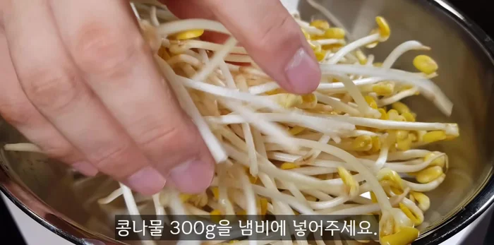 Place 300g of bean sprouts in a pot, add 50-60ml of water, cover, and cook on high heat until steam rises (about 3 minutes).