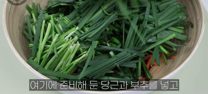 Add the prepared carrots and chives to the seasoning and mix gently.
