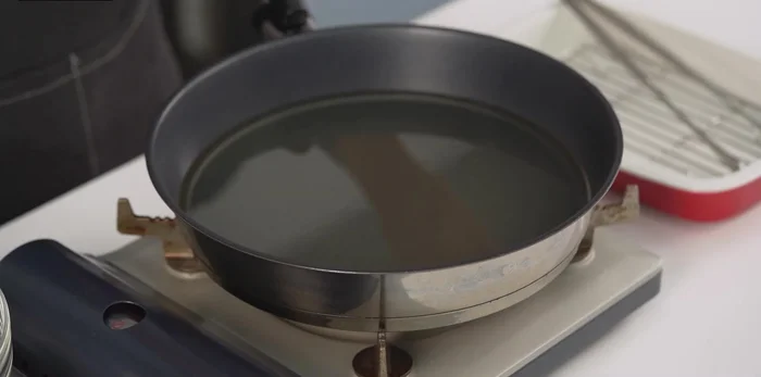 Heat cooking oil in a frying pan. Fry the tofu until golden brown, using two spoons to help shape the tofu into small balls or flat pieces.