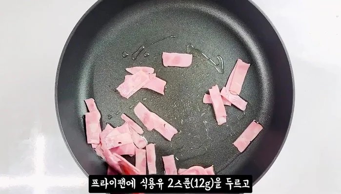 Heat cooking oil in a frying pan and fry the bacon until golden brown. Set aside.