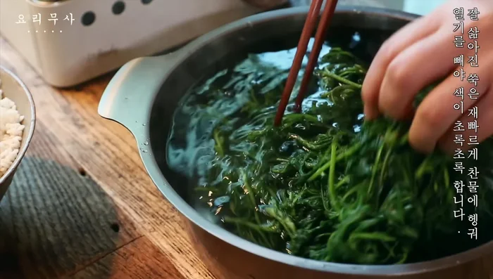 Rinse the boiled mugwort in cold water to remove heat and maintain its green color.