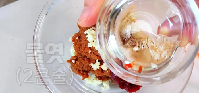 Make the seasoning sauce: In a bowl, combine red pepper powder, gochujang, minced garlic, soybean paste, sesame seeds (finely ground), and sesame oil. Mix well.