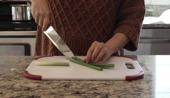 Finely chop green onion, onion, garlic, and red hot pepper (or substitute with red sweet pepper or carrot).