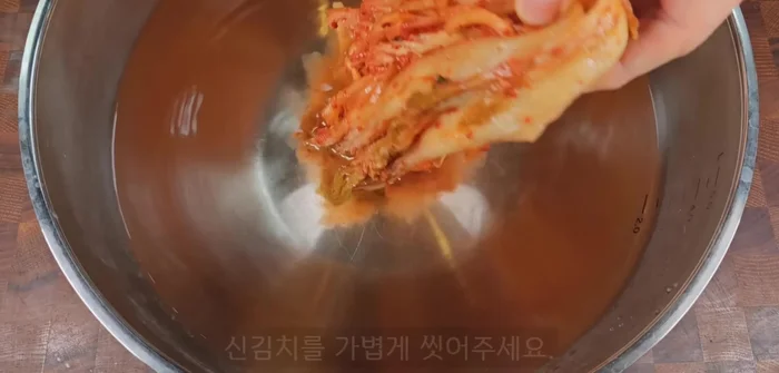 Rinse the kimchi seasoning lightly to reduce its strong sour taste. Squeeze out excess water and slice into 1cm intervals.