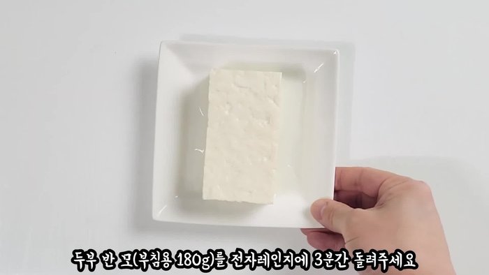 Microwave the tofu block for 3 minutes to evaporate moisture and make it plump. Let it sit, then wipe off any surface moisture with a kitchen towel.