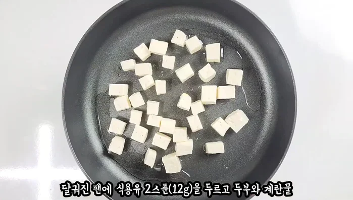 Heat cooking oil in a pan. Add tofu, then eggs, sauce, green onion, and chili pepper. Cover and cook over medium heat until done.