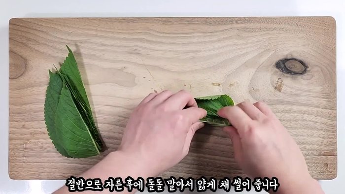 Wash sesame leaves thoroughly (three times) and cut them in half. Roll and thinly slice them.