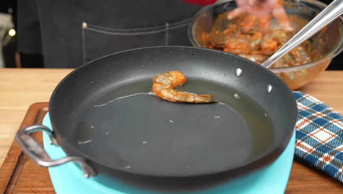 Heat oil in the same pan, add shrimp in a single layer, and sear for 2-3 minutes per side. Pour in remaining marinade and let it thicken.