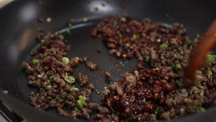 Reduce heat to low, add the seasoning paste, and sauté for 2 minutes.