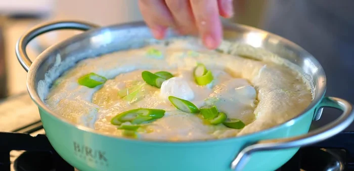 Add sliced green onion, stir occasionally to prevent sticking, and add a pinch of salt and a drizzle of sesame oil.