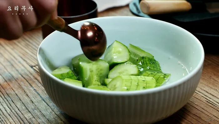 Add one tablespoon of cheonil and pour water over the cucumbers; let it sit.