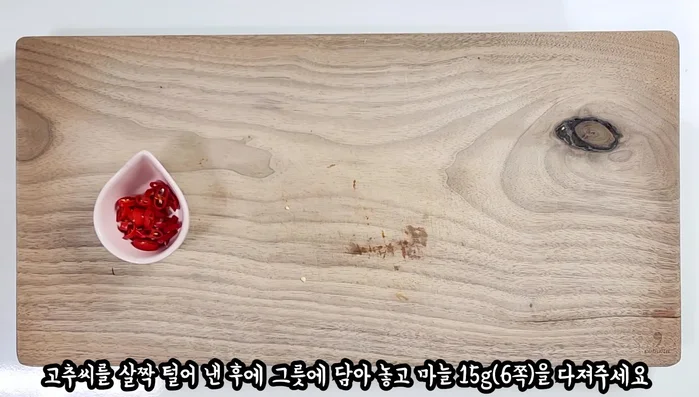 In a bowl, combine minced garlic (15g) with the chili pepper.
