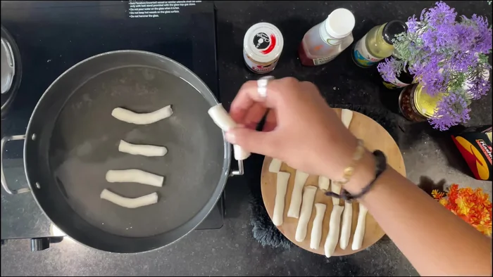 Boil the rice cakes in water for 15-20 minutes, ensuring they don't stick together. Transfer to cold water once cooked.