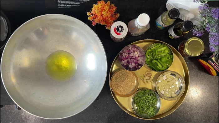 Heat oil in a pan. Add sesame seeds, then onions, garlic, and ginger, followed by capsicum.