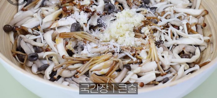 Season mushrooms with minced garlic, salt, soy sauce, and sesame oil. Mix well and let it sit.
