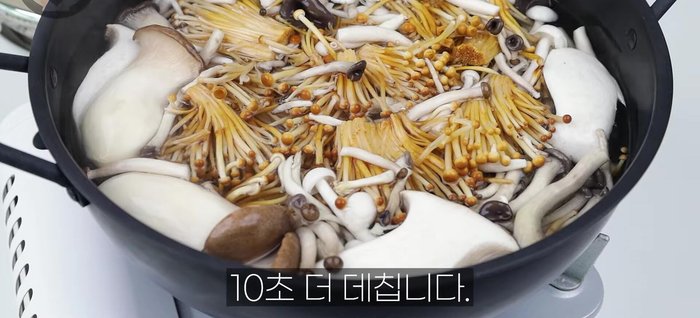 Stir-fry shiitake, man-ga-dak, and golden mushrooms for 10 seconds each.