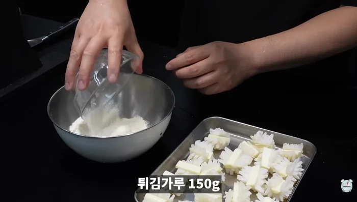 Prepare the tempura batter by mixing tempura flour, curry powder, and water.