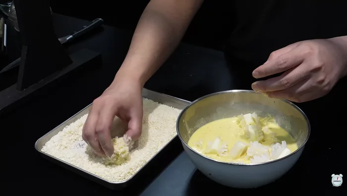 Coat the cheese-filled squid in the tempura batter, then evenly coat with breadcrumbs.