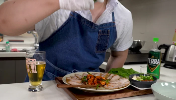 Assemble the wrap: Use rice paper to create wraps, layering the dried radish, cooked pork, and spicy cucumber salad.