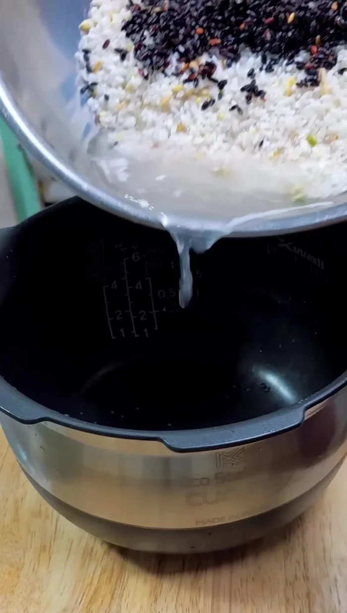 Add the mixed rice to the rice cooker.