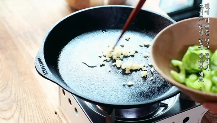 Add garlic and stir-fry, then add oil and stir-fry together.