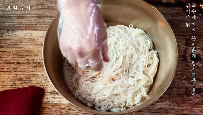 Mix in sesame oil to prevent the noodles from sticking, then add soy sauce and honey and mix.