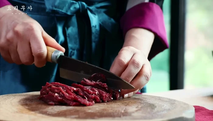Cut the beef into thin strips, leaving only a little fat, then slice thinly.