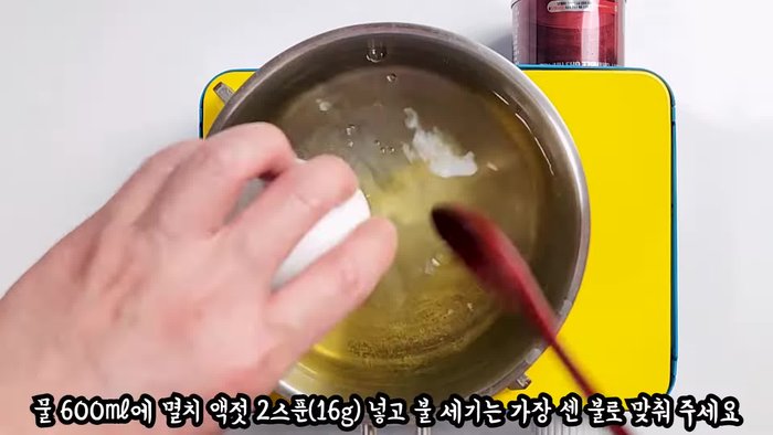 While the water is boiling, crack two eggs into the pot.