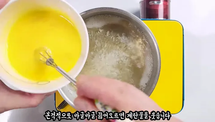 Once the water starts boiling, pour in the egg water. Break the egg in a circular motion, but be sure to keep the spoon from getting wet until it is cooked.