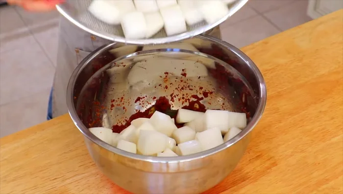 Combine the radish cubes with the kimchi paste, ensuring all the radish is well coated.