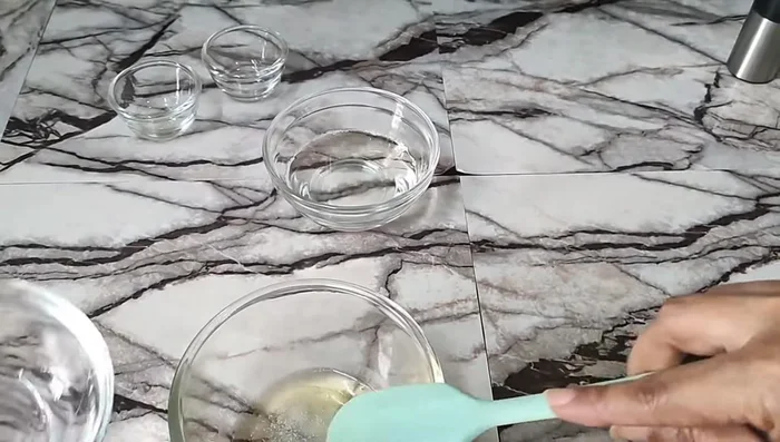 Combine the heated water phase into the oil phase, mixing well.
