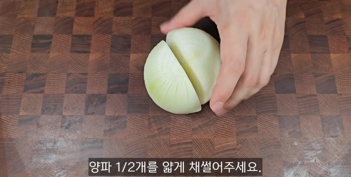 Prepare half an onion by thinly slicing it.