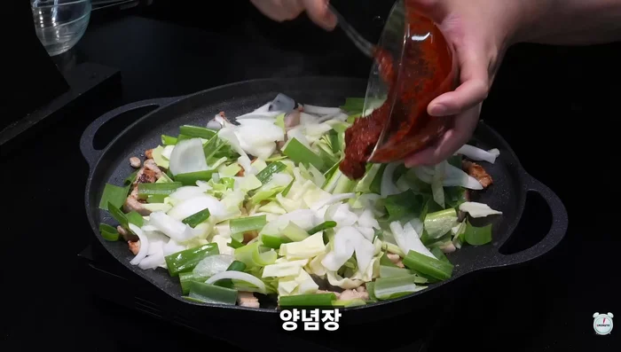 Add cabbage, green onions, onions, seasoning sauce, commercially available broth, ox bone soup, prepared cut octopus, and shrimp to a pot. Bring to a boil.