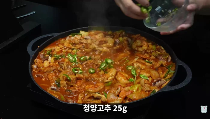Once shrimp and octopus are cooked, add green chili peppers and sesame oil.