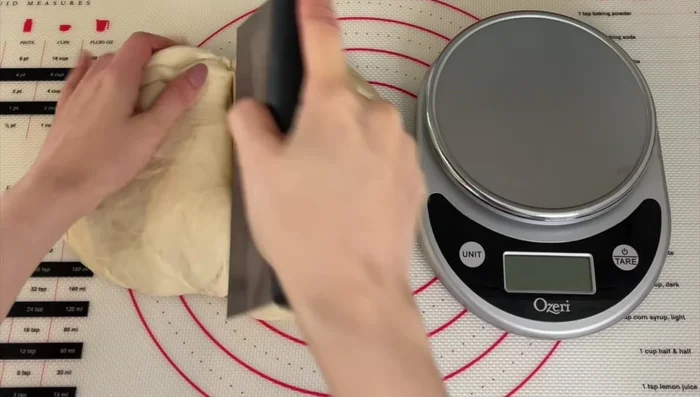 Punch down the dough and divide it into even pieces (about 6 oz each). Shape the dough into buns by gently stretching and tucking the edges.