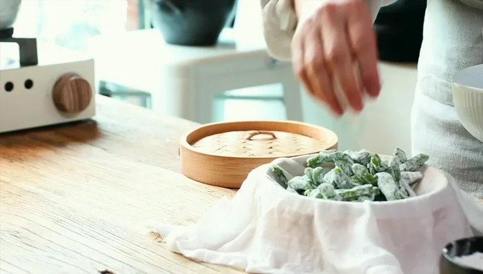 Steam the peppers: Place wet cotton pads in the steamer, add chili peppers, and steam for about 5 minutes after water boils. (125.479)