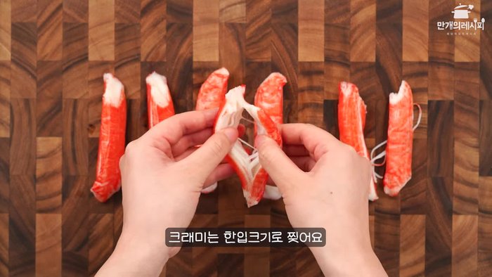 Prepare the crab sticks. (Detailed preparation steps are missing from the provided transcript. Assume this step involves thawing frozen crab sticks if needed, and potentially cutting them into smaller pieces if desired.)