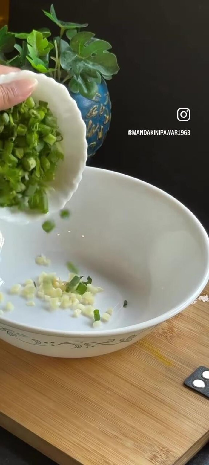 Prepare the seasoning: Mix finely chopped garlic, spring onion, red chilli powder, soy sauce, and hot oil. Add sesame seeds.