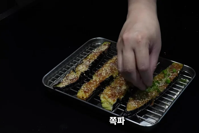 Sprinkle sesame seeds and green onions on the eggplant.