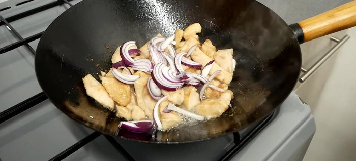 Add onions, a pinch of salt and MSG, and stir-fry until softened. Add noodles and cook for 20-25 seconds without stirring.