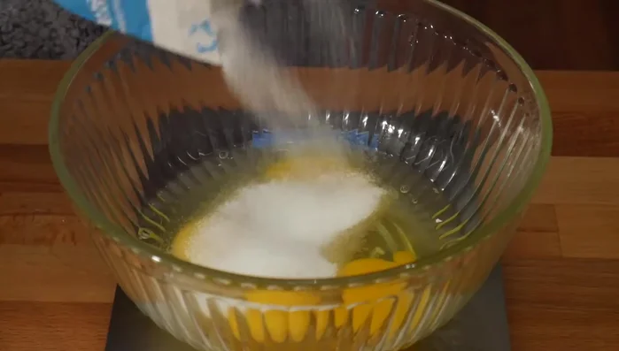 In a separate bowl, beat 4 large eggs with granulated sugar until tripled in volume and pale yellow.