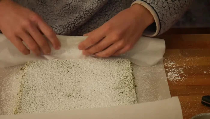Roll the cake up tightly using the parchment paper or tea towel. Let it cool completely to set the shape.