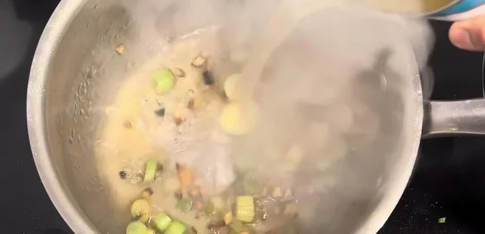 Add chicken broth to the pot.